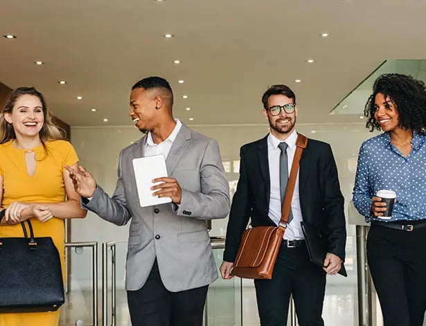 Four persons walking into work smiling